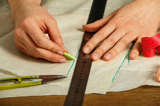 istock Professional tailor, fashion designer sitting and working at sewing studio. Needlework, tailoring,fashion, clothing repair and dressmaking concept. Sewing process, seamstress young woman working. 1302297672