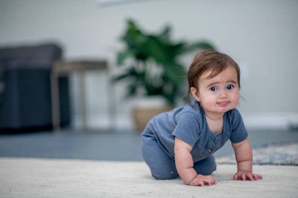 istock Cute baby girl is learning to crawl 1302297770