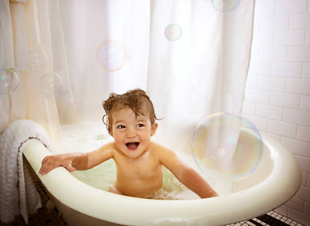 istock Little boy in bathtub playing with soap bubbles. 1302298118