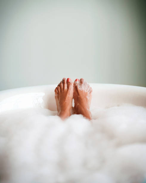Feet of woman in bubble bath relaxing. stock photo