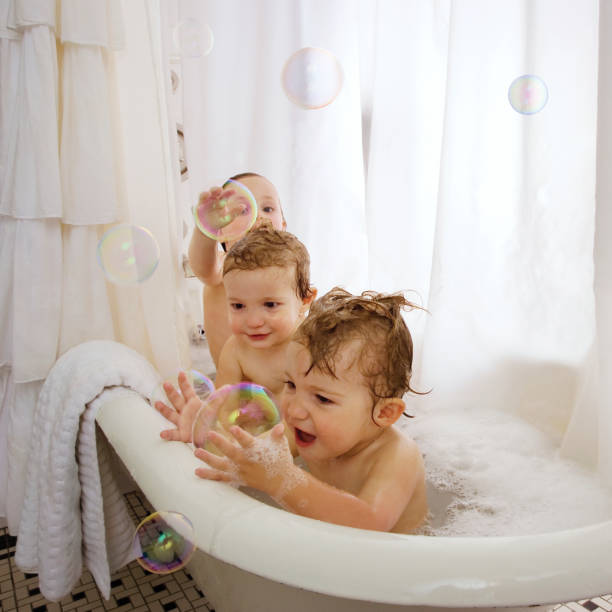 Babies in bathtub playing in a bubblebath.