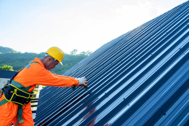 Roofer worker in special protective work wear use electric drill installing new roofs. Roofer worker in special protective work wear use electric drill installing new roofs with metal sheet on top of roof. consumerism stock pictures, royalty-free photos & images
