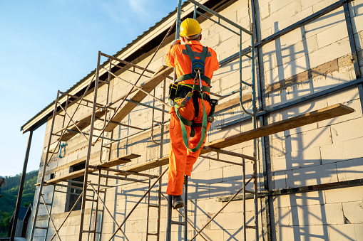 Trabajador de la construcción con cinturón de arnés de seguridad durante el trabajo en el lugar alto. photo