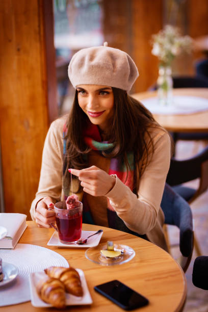 istock Attractive young woman sitting in the cafe and drinking tea 1302300532