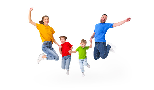 Positive couple and kids jumping with outstretched arms above ground in studio on white background while having fun and celebrating victory