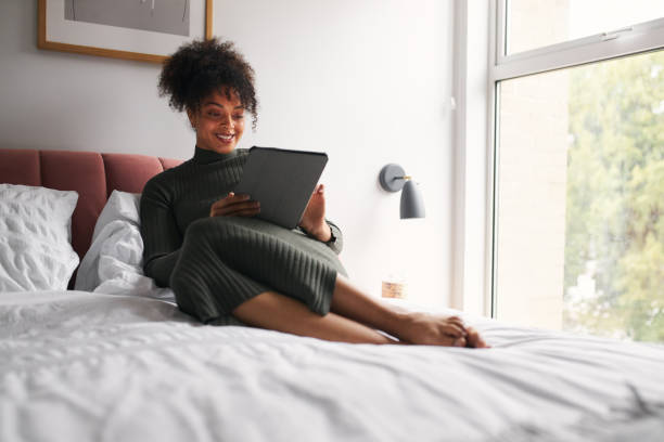 istock Woman Lying On Bed Reading Or Streaming Movie On Digital Tablet 1302302371