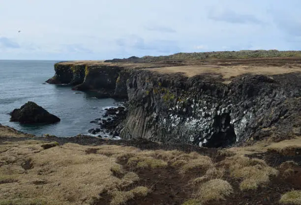 Towering hexagonal basalt columns running along the cliffs on the coast of Iceland.