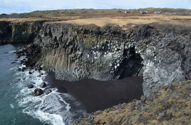 Stunning black sand beach with basalt column cavern located along Iceland's coast.