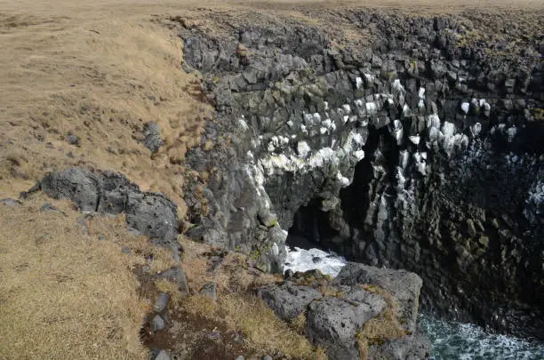 Unusual hexagonal basalt columns and rocky cliffs in Arnastapi Iceland.