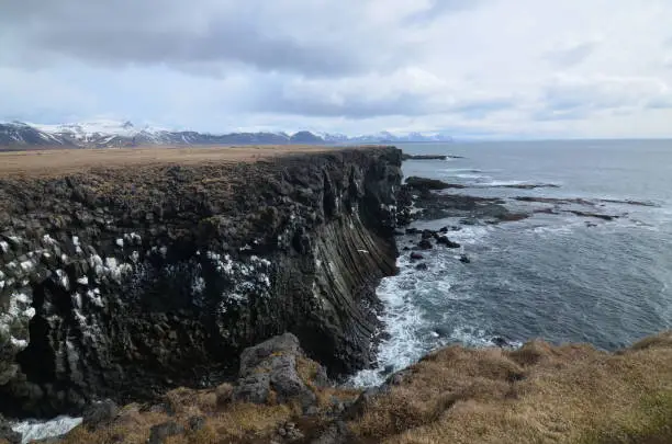 Rock bluffs and cliffs made of basalt columns along the coast.