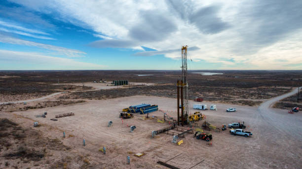 drone view of an oil or gas drill fracking rig pad with beautiful cloud filled sky - borehole imagens e fotografias de stock