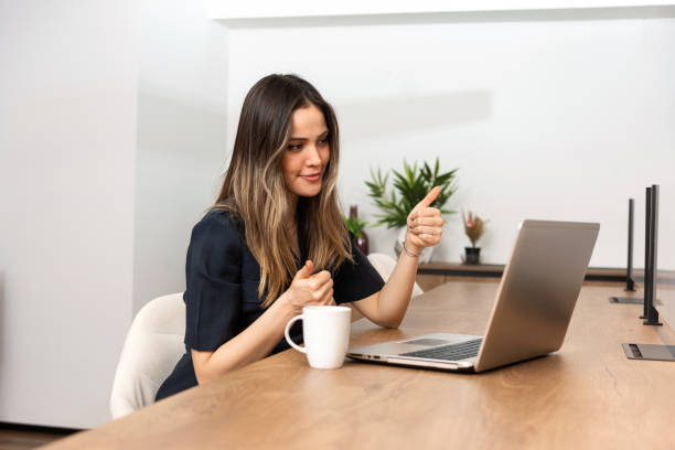 istock Young woman doing thumbs up during video call. 1302304008