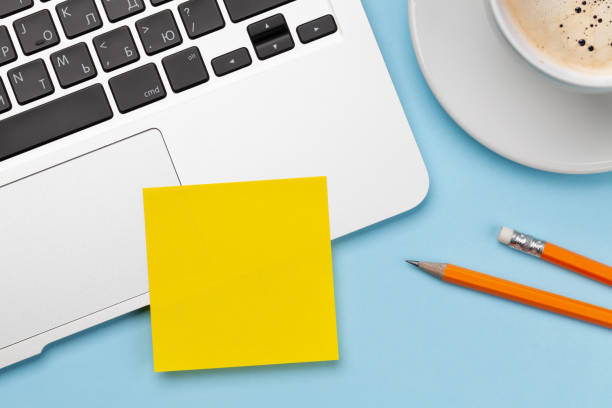 istock Office desk with yellow sticker, coffee and laptop 1302305500