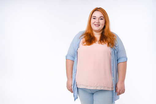 Portrait of a plus size redhead young woman in casual outfit isolated over white