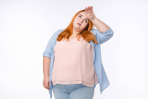 istock Exhausted ginger-haired plump woman isolated over white background 1302307254