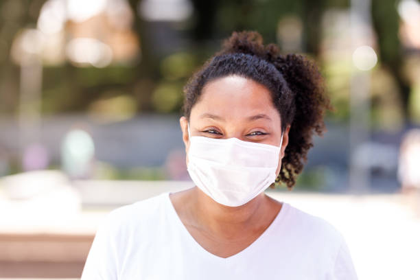 istock Woman smiling behind a protective face mask 1302307280