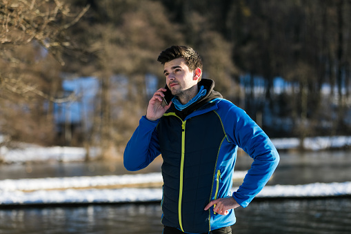 Young Caucasian man using mobile phone in winter