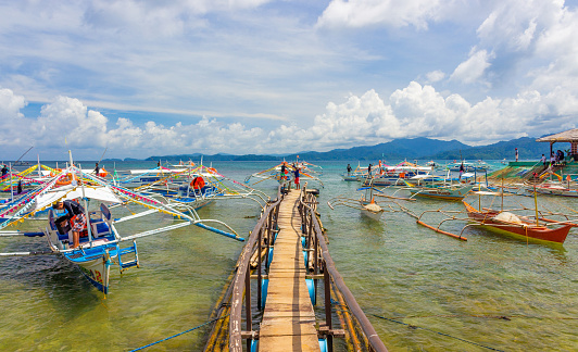 Sabang, Palawan, Philippines - September 26, 2018: traditional Filipino boats near wooden pier in the village of Sabang.