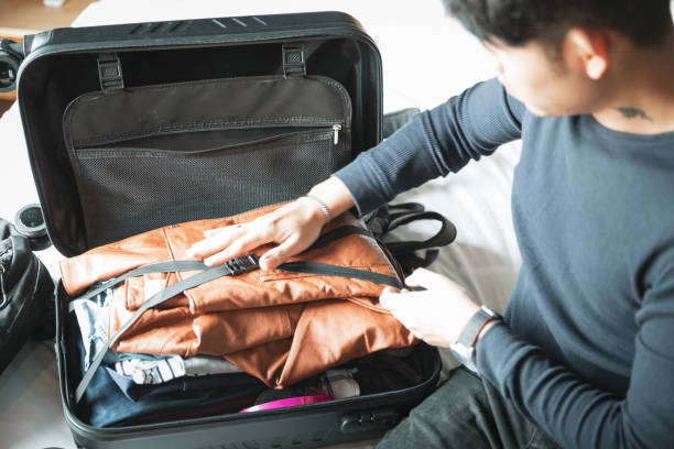 istock Young asian Man packing and get ready to go 1302311786