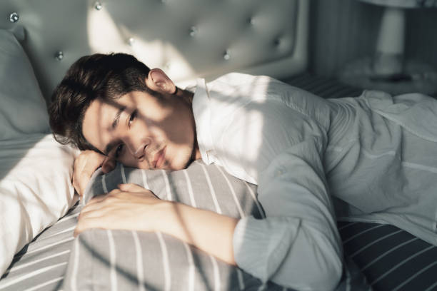 istock Young Asian handsome man lying down the bed in the day 1302311790