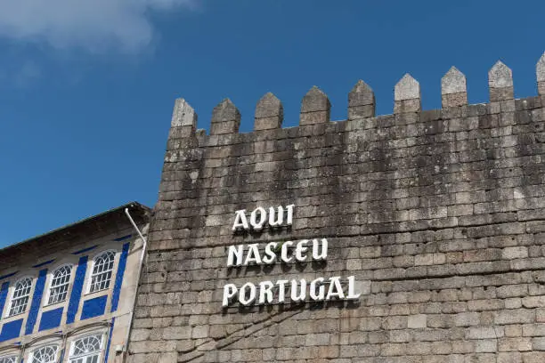 Portugal was born here saying in Portuguese is a famous place in Toural square at Guimaraes. Nice blue sky and a cloud offer copy space for a design