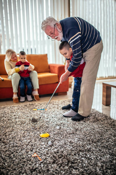 avô jogando golfe com seu neto em casa - golf women female concentration - fotografias e filmes do acervo