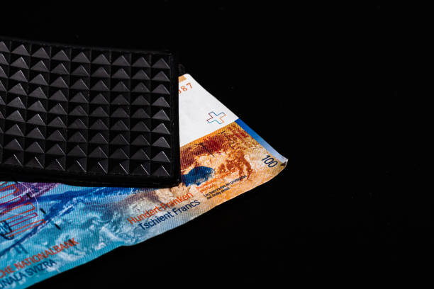 istock 100 swiss franc banknote in a black wallet isolated. 1302319303
