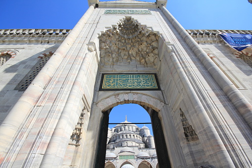Istanbul, Turkey-June 9, 2013: Front View of the Blue Mosque in Sultan Ahmet Square from the Exterior Door. There are Arabic inscriptions and stone carvings on the door.