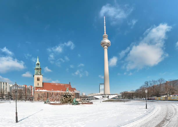 istock Berlin under snow. Panoramic image with television tower, Neptun fountain and Marienkirche, old church 1302320740