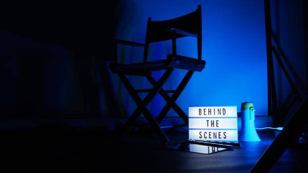 istock Behind the scenes letterboard text on Lightbox or Cinema Light box. Movie clapperboard megaphone and director chair beside. Background LED color change. static camera in video production studio. 1302321032