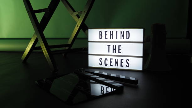 istock Behind the scenes letterboard text on Lightbox or Cinema Light box. Movie clapperboard megaphone and director chair beside. Background LED color change. static camera in video production studio. 1302321034