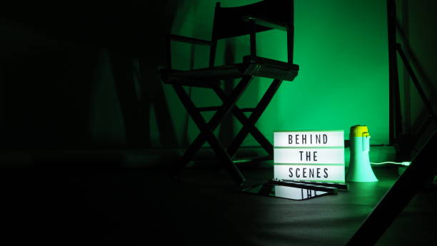 istock Behind the scenes letterboard text on Lightbox or Cinema Light box. Movie clapperboard megaphone and director chair beside. Background LED color change. static camera in video production studio. 1302321037