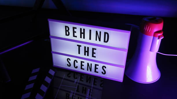 istock Behind the scenes letterboard text on Lightbox or Cinema Light box. Movie clapperboard megaphone and director chair beside. Background LED color change. static camera in video production studio. 1302321039