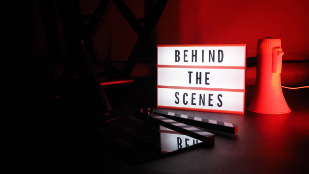 istock Behind the scenes letterboard text on Lightbox or Cinema Light box. Movie clapperboard megaphone and director chair beside. Background LED color change. static camera in video production studio. 1302321042