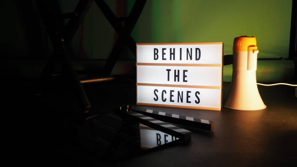 istock Behind the scenes letterboard text on Lightbox or Cinema Light box. Movie clapperboard megaphone and director chair beside. Background LED color change. static camera in video production studio. 1302321044