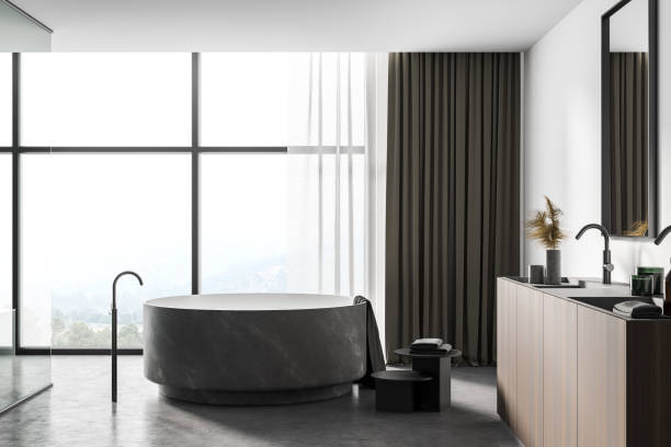istock White bathroom interior with round tub and sink, side view 1302322100