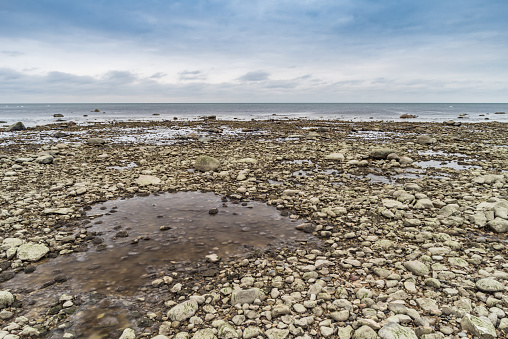 rocky beach in winter, view from the rocky beach to the sea, icy sea, high resolution photo
