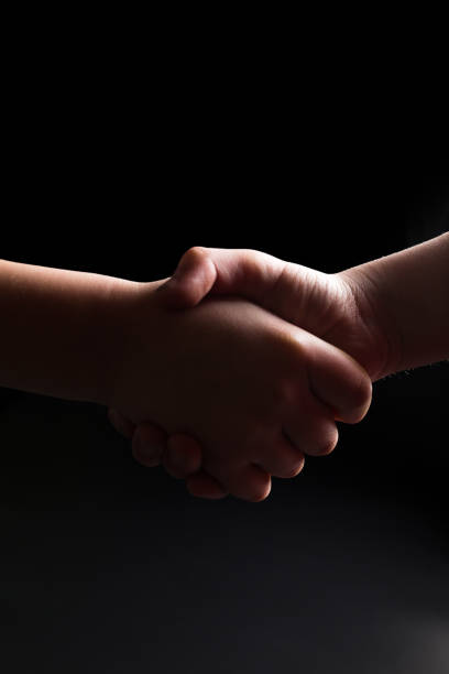 Handshake in dark. Informal arrangement. Shadow business