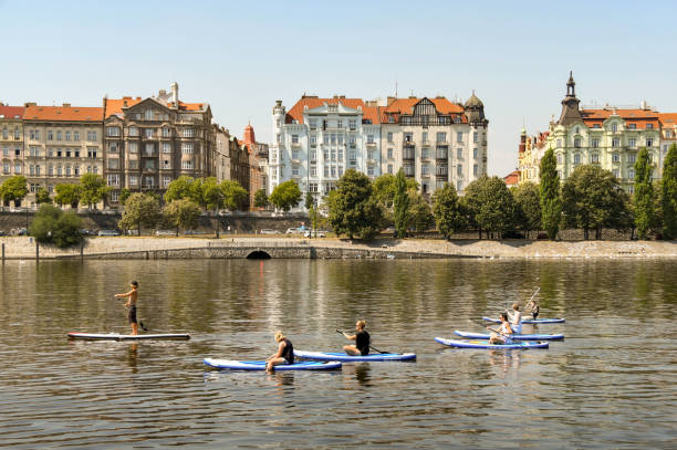 People paddle boarding on the river Vltava in Prague Prague, Czech Republic - August 2018: Group of people paddleboarding on the River Vltava in Prague. vltava river stock pictures, royalty-free photos & images