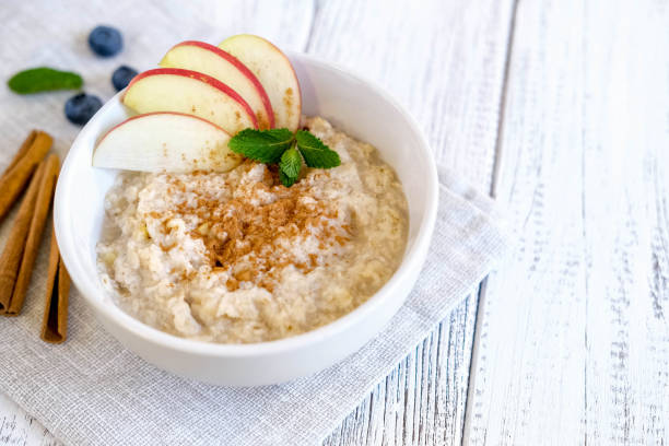 deliciosas gachas con manzana y canela. desayuno natural fresco servido sobre mesa de madera - oatmeal fotografías e imágenes de stock