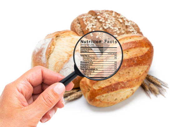 Hand holding magnifying glass looking for nutritional information on bread