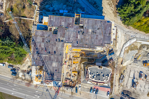 Working at the construction site, building a new house. Aerial top view from drone