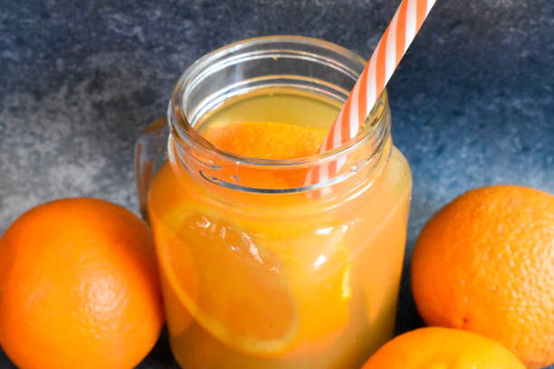istock Orange juice with oranges on a blue background 1302329391