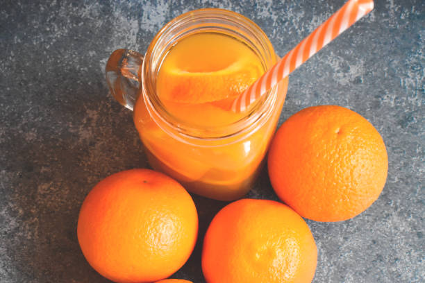 istock Orange juice with oranges on a blue background 1302329506