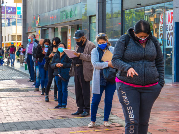 People with facemask in line on some Street in Bogota - Colombia stock photo