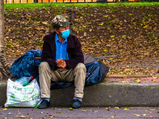 Homeless old man in the street with facemask stock photo