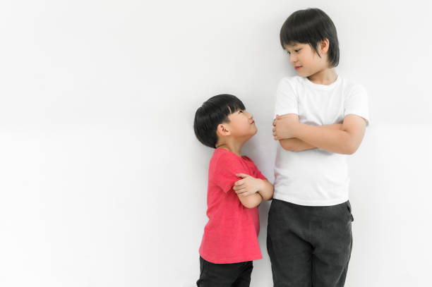 niño pequeño y niño alto con los brazos cruzados y mirando la cara - bajo estatura humana fotografías e imágenes de stock