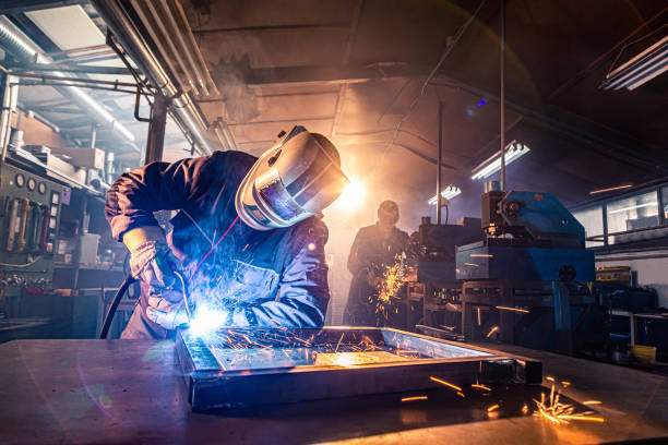 istock Two handymen welding and grinding metal at workshop 1302330486