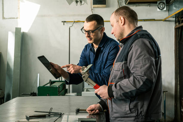 istock A tinsmith and his fellow colleague engineer in the workshop 1302330922