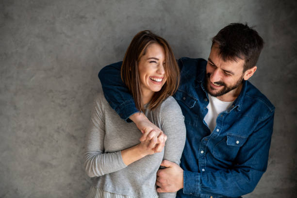 Couple in love, hugging and smiling. Gray background. Copy- space. stock photo